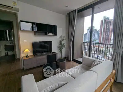Modern living room with city view, featuring sleek furniture and large windows for natural light.