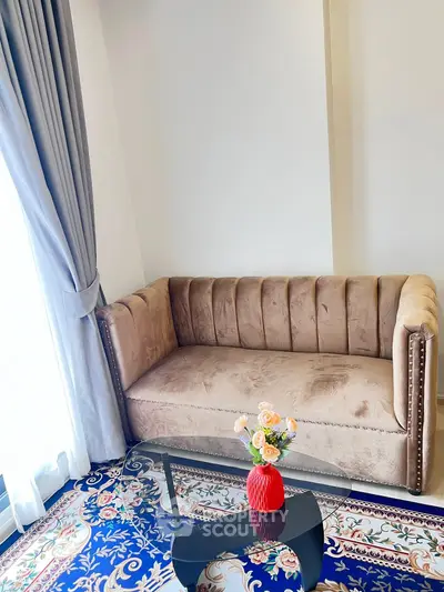 Elegant living room with plush sofa and floral decor, perfect for cozy relaxation.