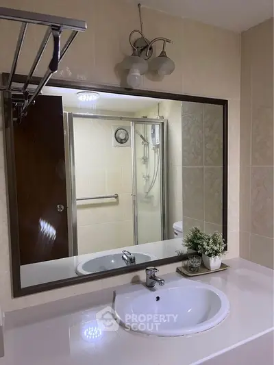 Modern bathroom with large mirror and sleek fixtures