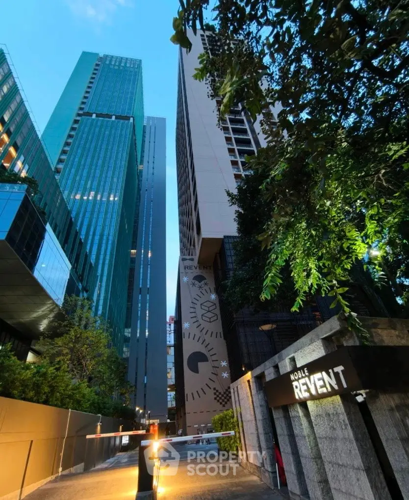 Stunning modern high-rise buildings with lush greenery and elegant entrance at dusk.