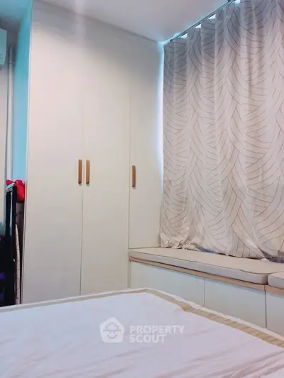 Cozy bedroom with built-in wardrobe and window seat, perfect for relaxation.