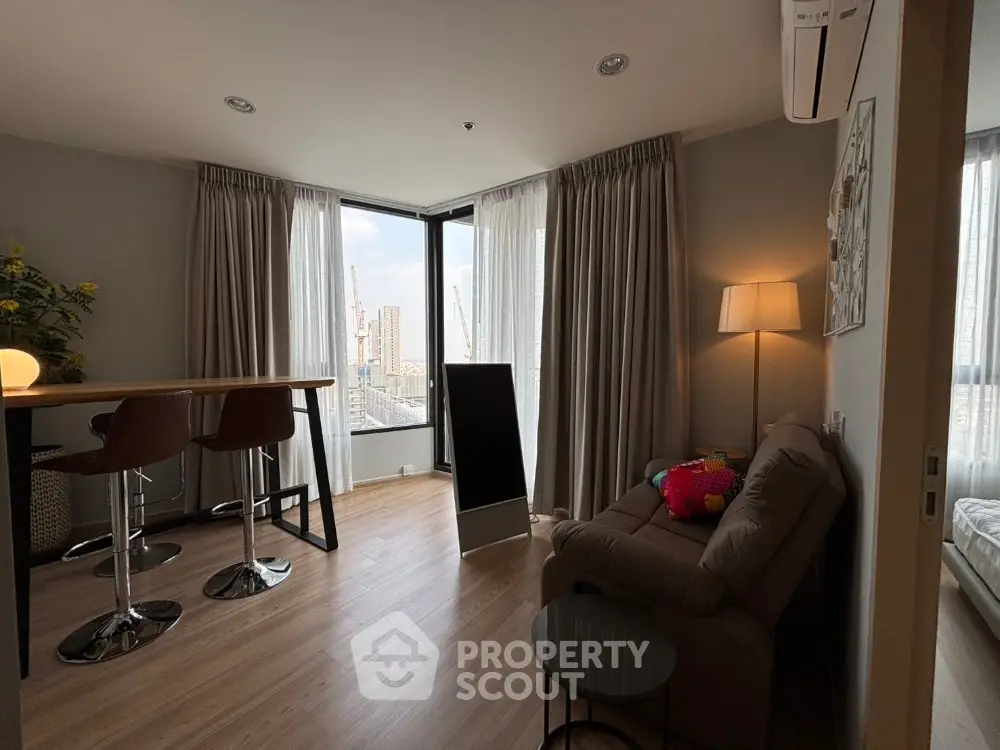 Modern living room with city view, cozy seating, and stylish bar stools.