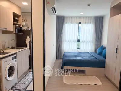 Modern studio apartment with cozy bedroom and compact kitchen featuring washing machine.