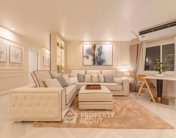 Luxurious living room with elegant beige sofa, plush rug, and modern decor in a stylish apartment.