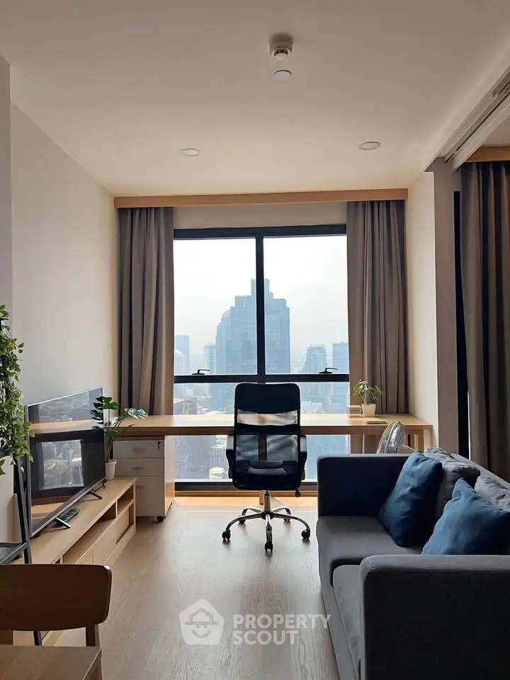 Modern living room with city view, featuring sleek furniture and large window.
