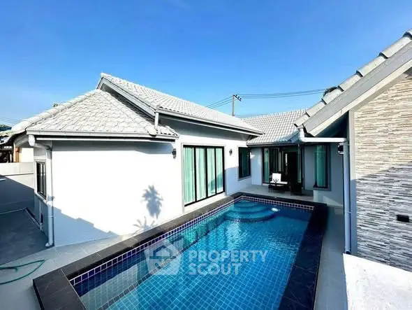 Stunning modern villa with private pool and sleek architecture under clear blue skies.