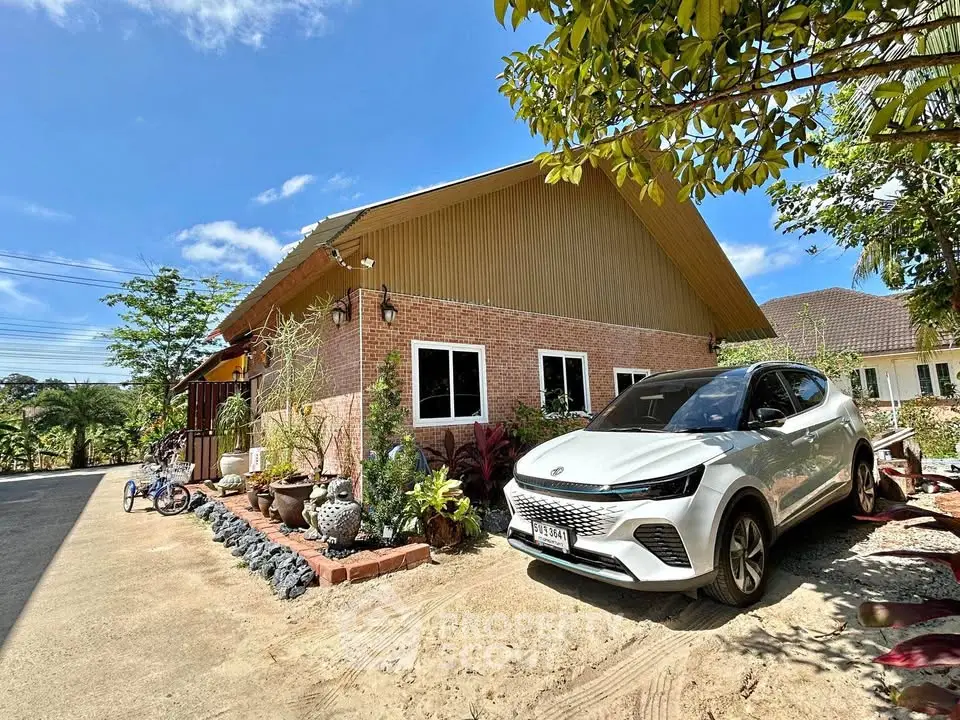 Charming suburban home with brick facade and lush garden, featuring a modern car parked in the driveway.