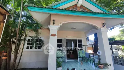 Charming single-story home with inviting porch and lush greenery, perfect for tranquil living.