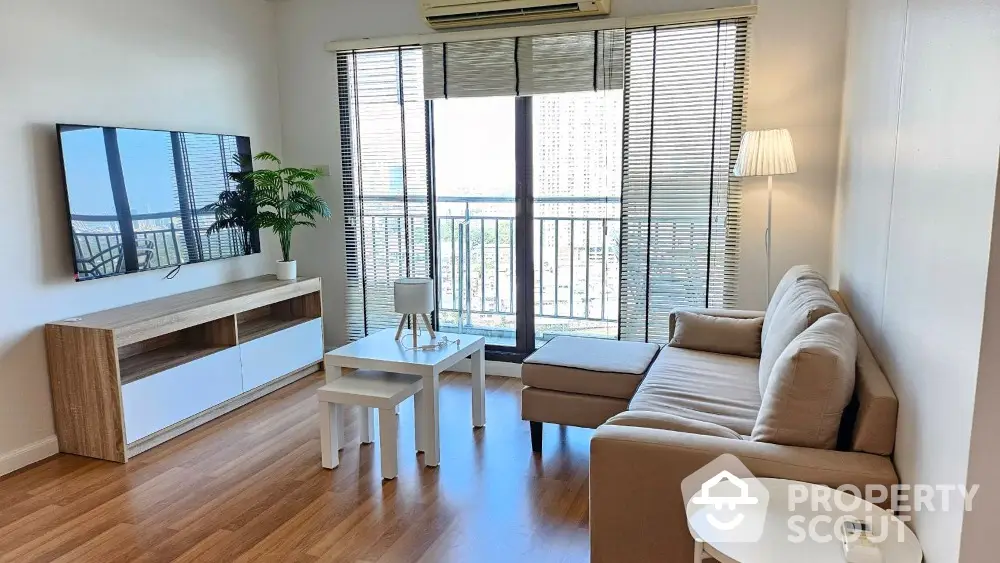 Modern living room with large windows and stylish furniture in a high-rise apartment.