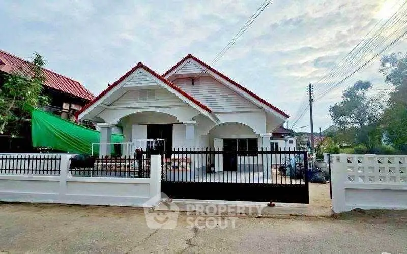 Charming single-story house with red roof and spacious front yard, perfect for family living.