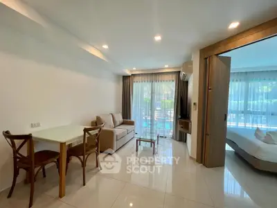 Modern living room with pool view, featuring cozy seating and dining area, perfect for relaxation.