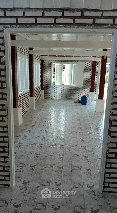 Spacious interior with brick walls and tiled flooring, perfect for customization.