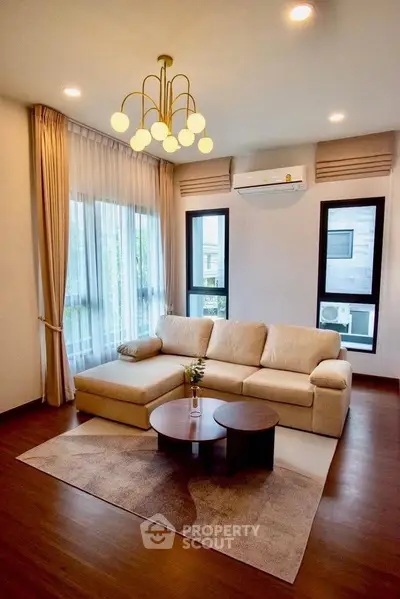 Elegant living room with modern chandelier and cozy sectional sofa
