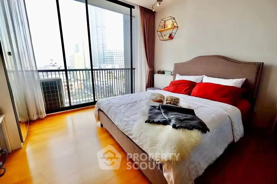 Luxurious bedroom with city view, elegant decor, and natural light in modern apartment.