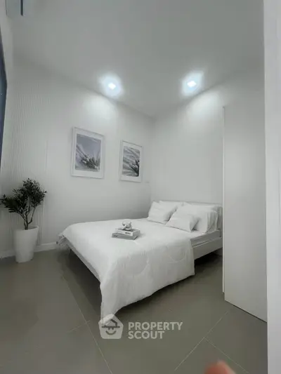 Modern minimalist bedroom with white decor and stylish artwork