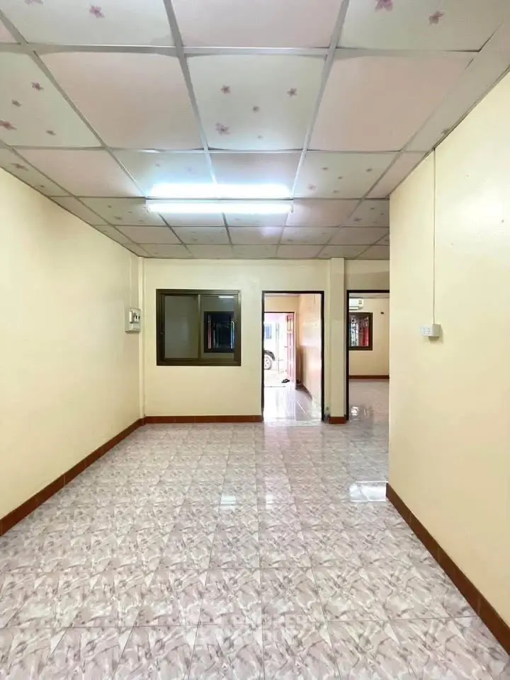 Spacious interior with tiled flooring and ceiling lights, ideal for versatile living space.