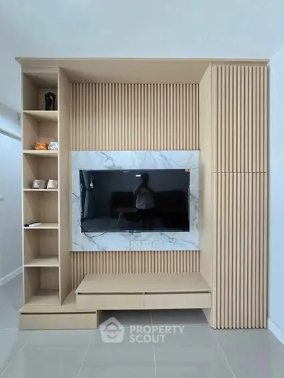 Modern living room with sleek wooden TV unit and marble accents
