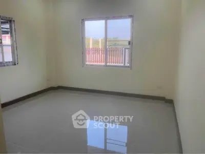Spacious empty room with large window and glossy tiled floor