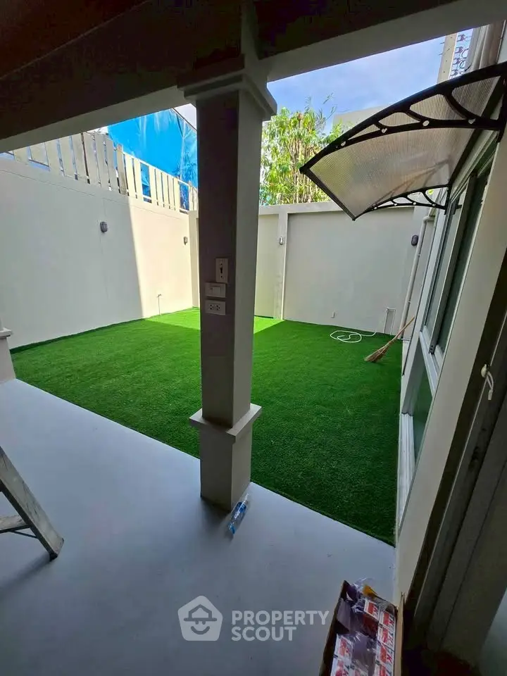 Charming private garden with artificial grass and modern design, perfect for relaxation and outdoor activities.