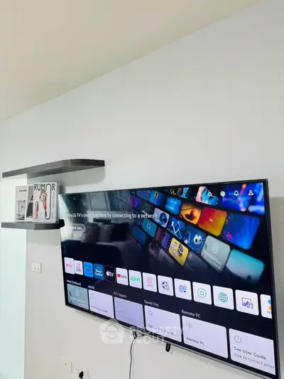 Modern living room with wall-mounted smart TV and stylish shelving.
