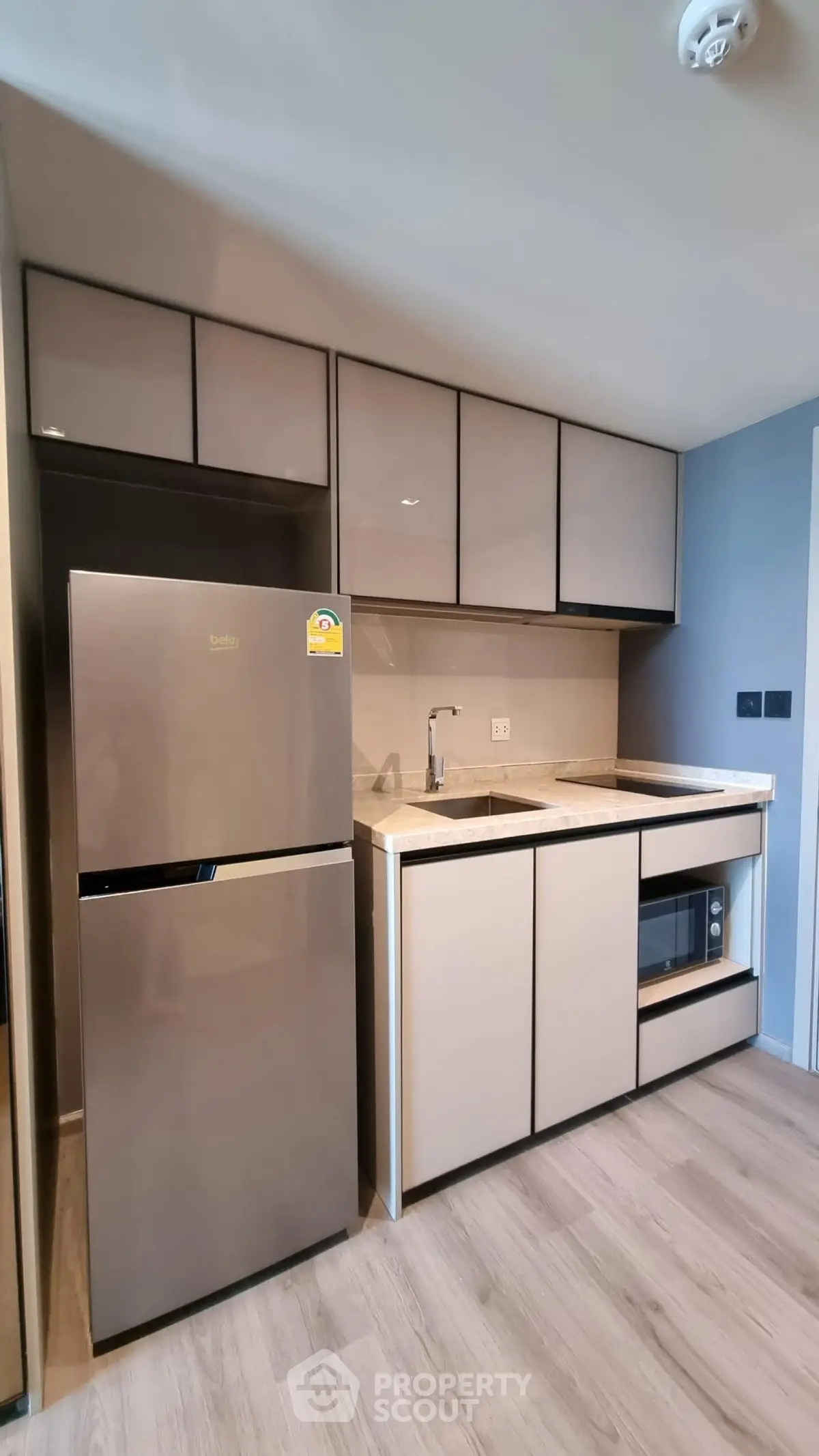 Modern kitchen with sleek cabinetry and stainless steel appliances in a stylish apartment.