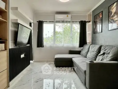 Modern living room with sleek design, large window, and comfortable gray sofa.