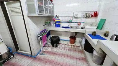 Spacious kitchen with ample storage and tiled flooring, featuring a practical closed layout and modern appliances.