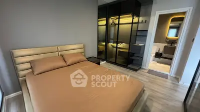 Modern bedroom with sleek design and ensuite bathroom, featuring a stylish wardrobe and cozy bed.