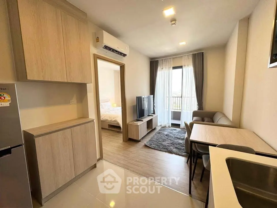 Modern apartment interior with open layout, cozy living area, and natural light from balcony.