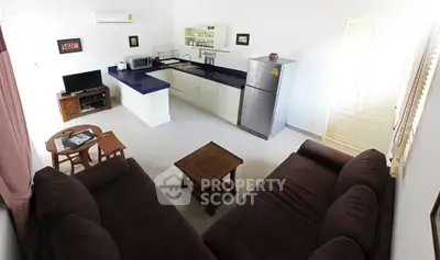 Spacious open-plan living room with modern kitchen and cozy seating area.