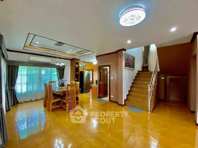 Spacious living room with dining area and staircase in modern home