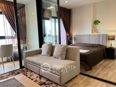 Modern studio apartment with cozy living area and stylish bedroom, featuring floor-to-ceiling windows and elegant decor.