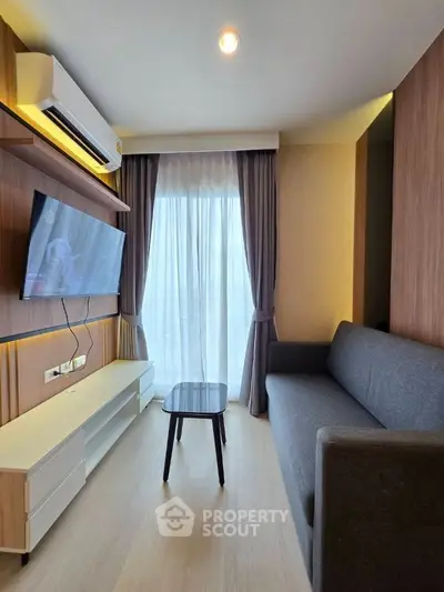 Modern living room with sleek furniture and large window for natural light.