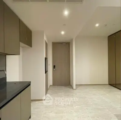 Modern minimalist kitchen with sleek cabinetry and tiled flooring