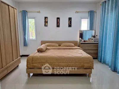 Spacious bedroom with elegant decor and natural light, featuring a large bed and stylish furnishings.