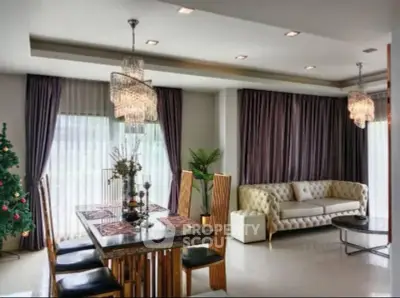 Luxurious living room with elegant dining area and plush sofa, featuring modern chandeliers and large windows.
