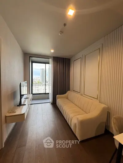 Modern living room with elegant sofa and wall-mounted TV, featuring a balcony view.