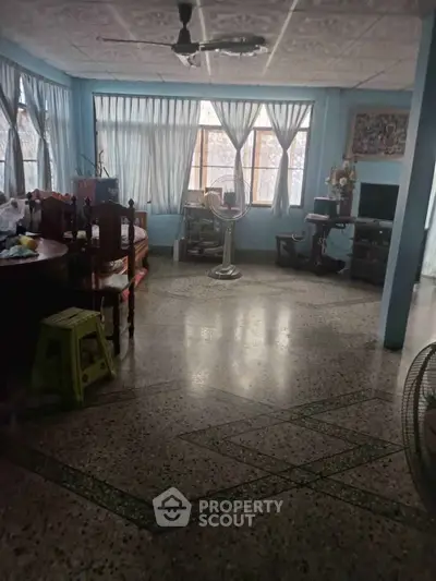 Spacious living room with large windows and classic decor