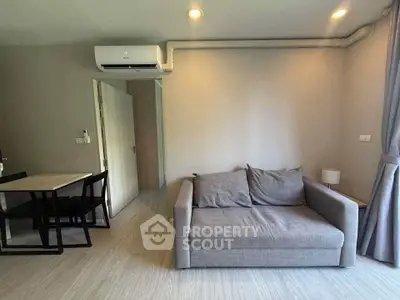 Modern living room with cozy gray sofa and dining area in stylish apartment.