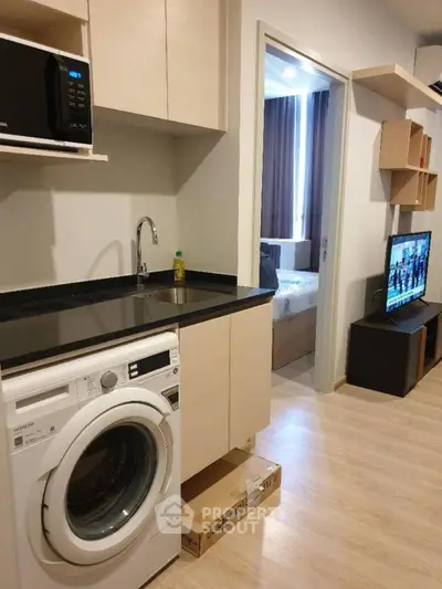 Modern apartment interior with washing machine and open kitchen layout