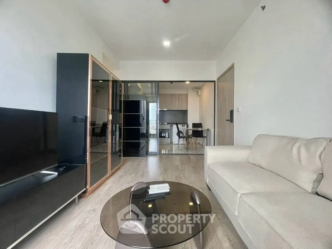 Modern living room with sleek furniture and open kitchen layout in a stylish apartment.