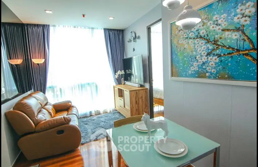 Stylish living room with modern decor, large window, and cozy seating area in a contemporary apartment.
