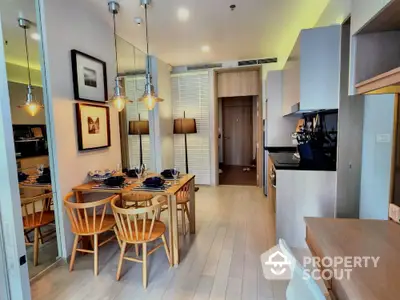 Modern dining area with stylish lighting and wooden furniture in a cozy apartment.