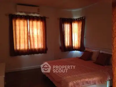 Cozy bedroom with warm lighting and elegant curtains, perfect for relaxation.