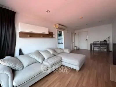 Spacious living room with modern sofa and wooden flooring in a stylish apartment.
