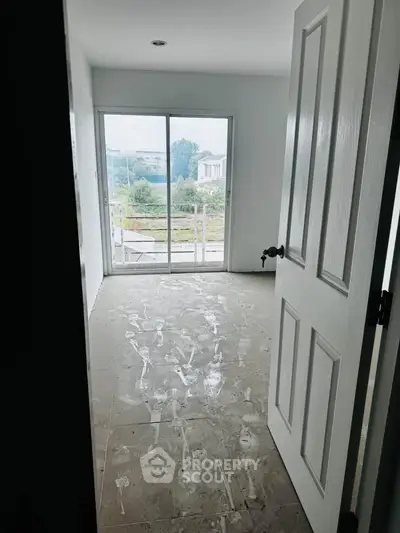 Spacious room with large window offering scenic views, perfect for customization in a modern home.