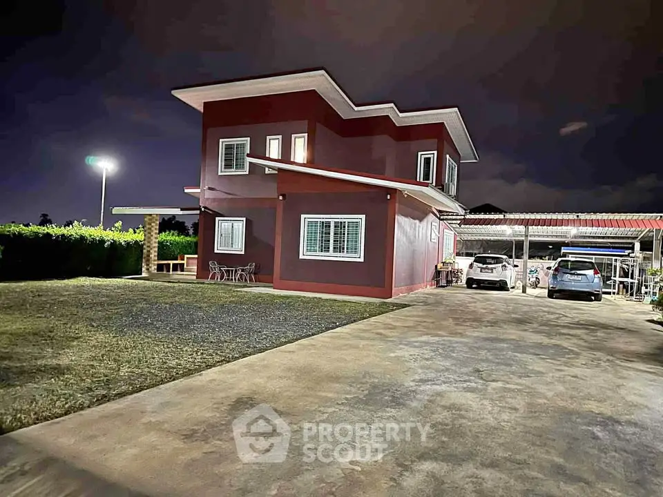 Modern two-story house with spacious driveway and night lighting
