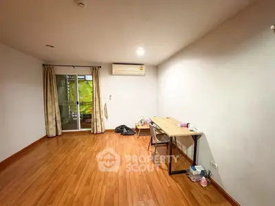 Spacious study room with wooden flooring and natural light