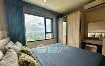 Modern bedroom with city view, featuring large window and stylish decor.