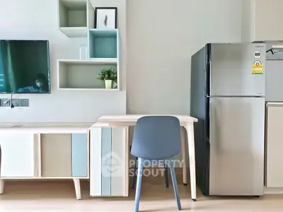 Modern living space with stylish furniture and stainless steel fridge, perfect for urban living.